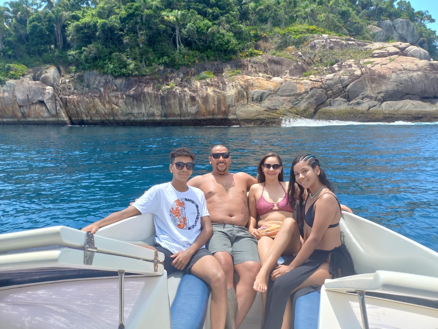 Grupo de amigos sorrindo na proa da lancha
